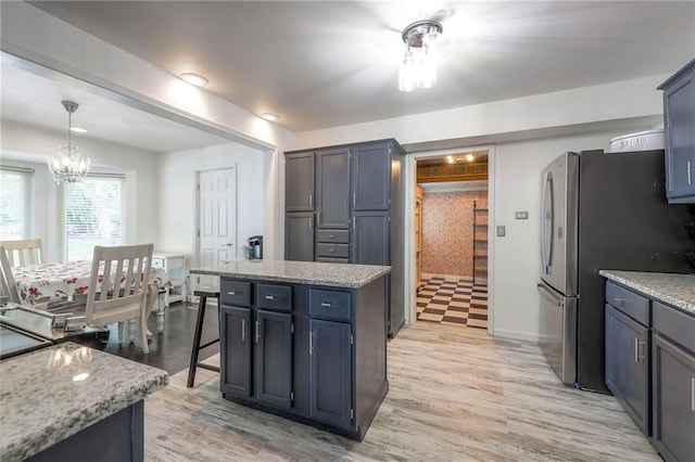 14001 S Tomahawk Dr, Olathe, KS 66062 - kitchen featuring freestanding refrigerator, a chandelier, light wood finished floors, and a kitchen island