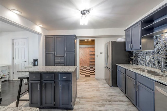 14001 S Tomahawk Dr, Olathe, KS 66062 - kitchen with stainless steel appliances, backsplash, light stone counters, light wood-style flooring, and open shelves