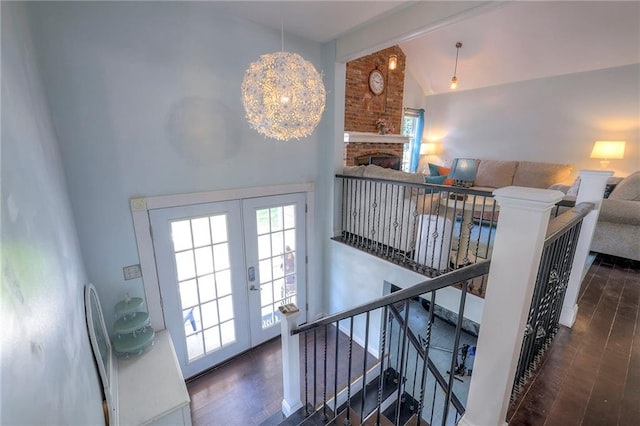 14001 S Tomahawk Dr, Olathe, KS 66062 - stairs with wood finished floors, vaulted ceiling, french doors, and a brick fireplace