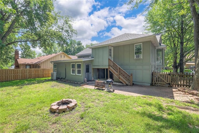 14001 S Tomahawk Dr, Olathe, KS 66062 - rear view of property featuring a fire pit, board and batten siding, a shingled roof, and a patio
