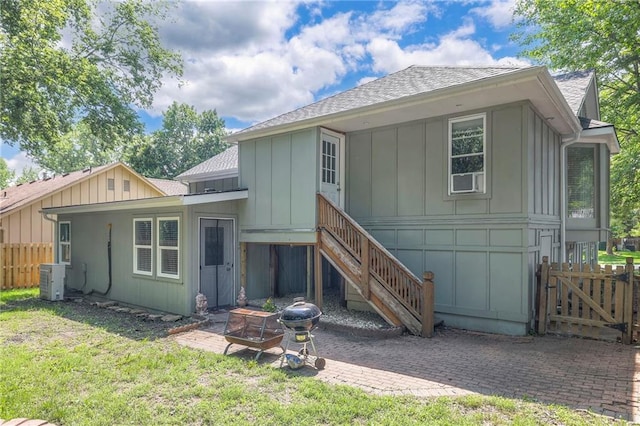 14001 S Tomahawk Dr, Olathe, KS 66062 - rear view of house with board and batten siding, a shingled roof, a patio, and a fire pit