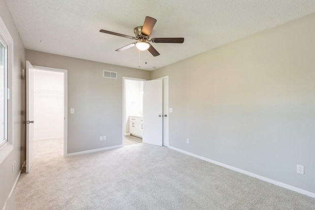 105 S W St, Concordia, MO 64020 - unfurnished bedroom with light colored carpet, a textured ceiling, ceiling fan, and ensuite bathroom