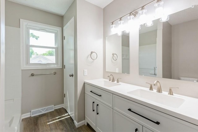 105 S W St, Concordia, MO 64020 - bathroom featuring wood finished floors and double vanity