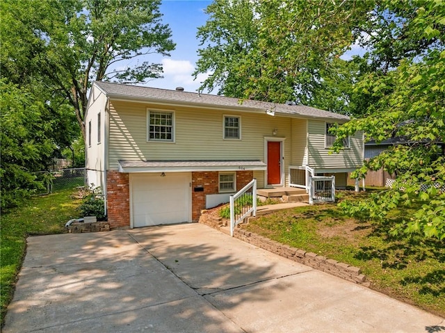 604 NE Ash St NE, Lees Summit, MO 64063 - split foyer home with a garage, driveway, and brick siding