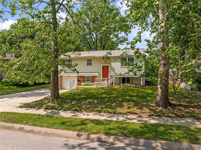 604 NE Ash St NE, Lees Summit, MO 64063 - raised ranch with concrete driveway, a garage, brick siding, and a front yard
