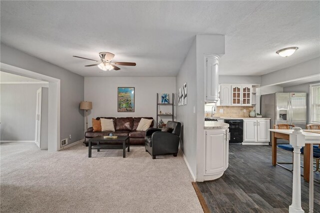 604 NE Ash St NE, Lees Summit, MO 64063 - living room with a ceiling fan, baseboards, a textured ceiling, ornate columns, and dark wood-style floors