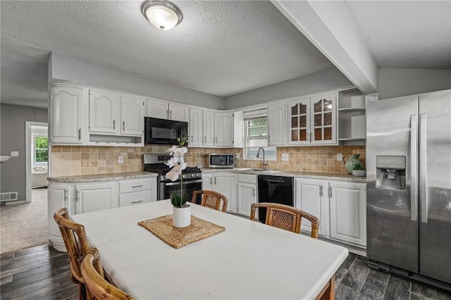 604 NE Ash St NE, Lees Summit, MO 64063 - kitchen with black appliances, white cabinetry, a sink, light countertops, and plenty of natural light