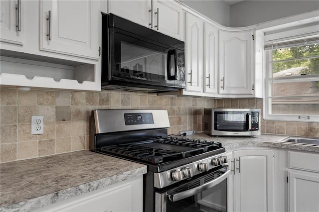 604 NE Ash St NE, Lees Summit, MO 64063 - kitchen with appliances with stainless steel finishes, white cabinetry, tasteful backsplash, light countertops, and open shelves