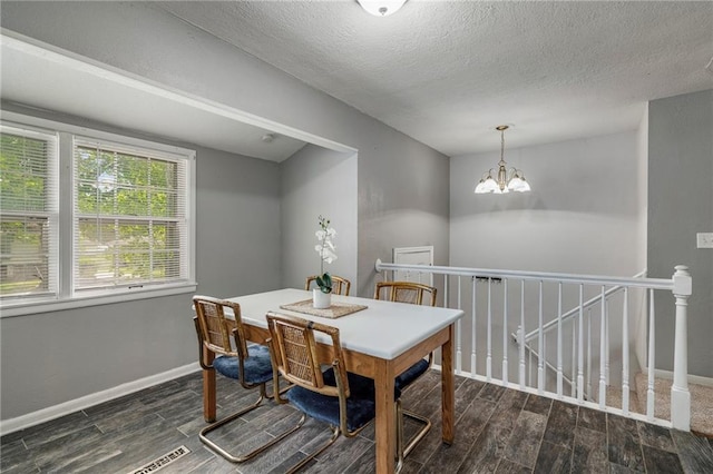 604 NE Ash St NE, Lees Summit, MO 64063 - dining room featuring wood finished floors, baseboards, a textured ceiling, and a chandelier