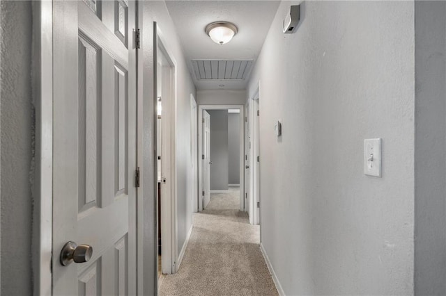 604 NE Ash St NE, Lees Summit, MO 64063 - hall with light colored carpet, attic access, baseboards, and a textured wall