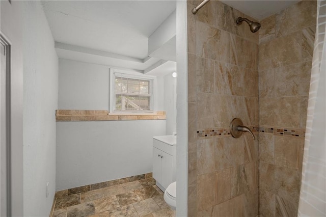 604 NE Ash St NE, Lees Summit, MO 64063 - bathroom with a tile shower, vanity, toilet, baseboards, and stone finish flooring