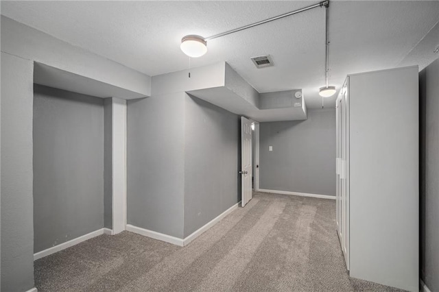 604 NE Ash St NE, Lees Summit, MO 64063 - finished basement with carpet, a textured ceiling, and baseboards