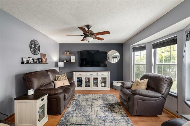 1229 SE Princeton Dr, Lees Summit, MO 64081 - living area with a ceiling fan, a textured ceiling, and light wood-style floors