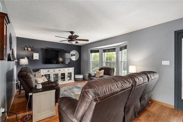 1229 SE Princeton Dr, Lees Summit, MO 64081 - living area featuring a ceiling fan, light wood-style flooring, and a textured ceiling