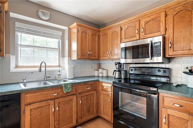 1229 SE Princeton Dr, Lees Summit, MO 64081 - kitchen with black appliances, brown cabinets, tasteful backsplash, and a textured ceiling