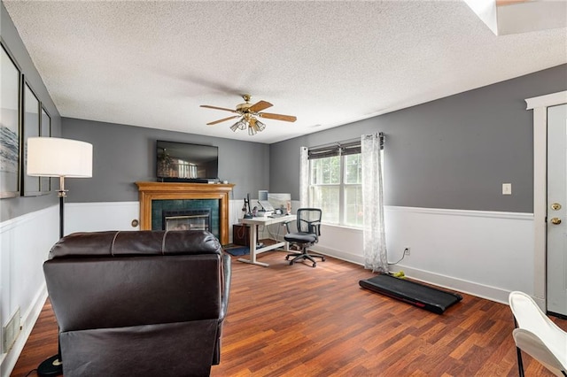 1229 SE Princeton Dr, Lees Summit, MO 64081 - living room with a textured ceiling, a ceiling fan, wood finished floors, a tile fireplace, and an office area