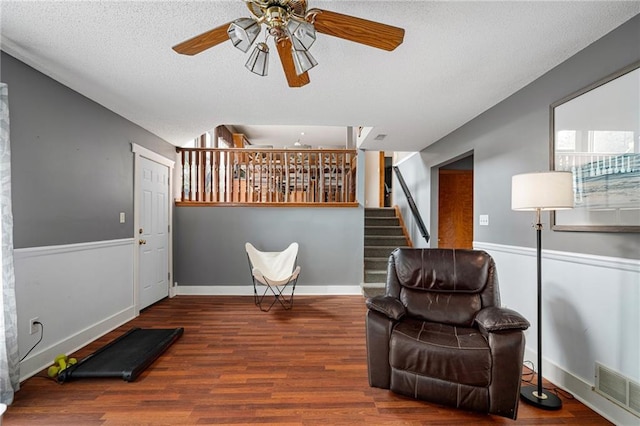 1229 SE Princeton Dr, Lees Summit, MO 64081 - living area with ceiling fan, wood finished floors, a textured ceiling, and stairs