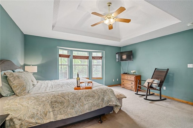 1229 SE Princeton Dr, Lees Summit, MO 64081 - carpeted bedroom featuring a tray ceiling and a ceiling fan