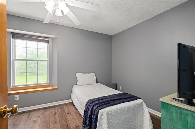 1229 SE Princeton Dr, Lees Summit, MO 64081 - bedroom featuring wood finished floors, a textured ceiling, and ceiling fan