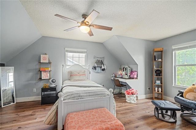1229 SE Princeton Dr, Lees Summit, MO 64081 - bedroom with wood finished floors, multiple windows, vaulted ceiling, ceiling fan, and a textured ceiling