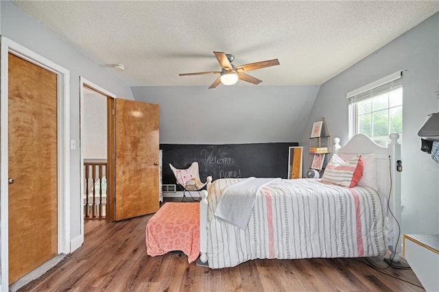 1229 SE Princeton Dr, Lees Summit, MO 64081 - bedroom featuring wood finished floors, lofted ceiling, a textured ceiling, and a ceiling fan