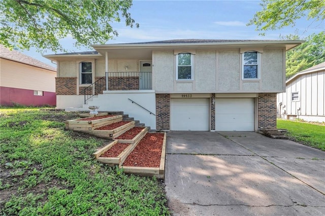 19133 E 15th St N, Independence, MO 64056 - view of front of home featuring brick siding, driveway, stucco siding, and a garage