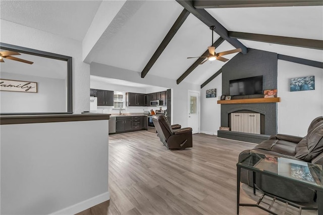 19133 E 15th St N, Independence, MO 64056 - living area featuring a ceiling fan, a fireplace, light wood-style flooring, and baseboards