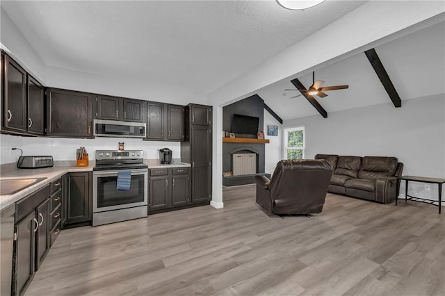 19133 E 15th St N, Independence, MO 64056 - kitchen with appliances with stainless steel finishes, ceiling fan, light countertops, a fireplace, and light wood-type flooring