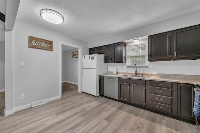 19133 E 15th St N, Independence, MO 64056 - kitchen with dishwasher, freestanding refrigerator, a sink, a textured ceiling, and light countertops
