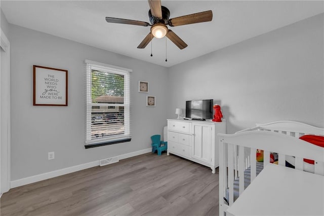 19133 E 15th St N, Independence, MO 64056 - bedroom featuring wood finished floors, a nursery area, baseboards, and a ceiling fan