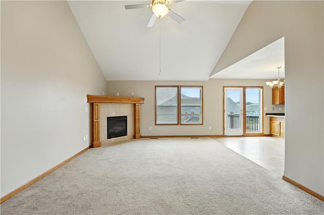 614 SW Tisha Ln, Grain Valley, MO 64029 - unfurnished living room featuring light colored carpet, vaulted ceiling, a chandelier, a tile fireplace, and ceiling fan