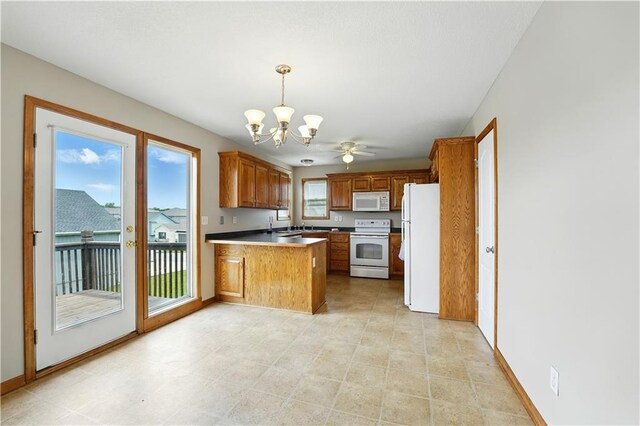 614 SW Tisha Ln, Grain Valley, MO 64029 - kitchen with white appliances, a peninsula, a chandelier, brown cabinets, and pendant lighting