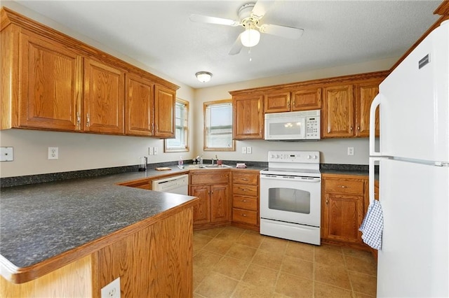 614 SW Tisha Ln, Grain Valley, MO 64029 - kitchen with white appliances, a peninsula, dark countertops, and brown cabinetry