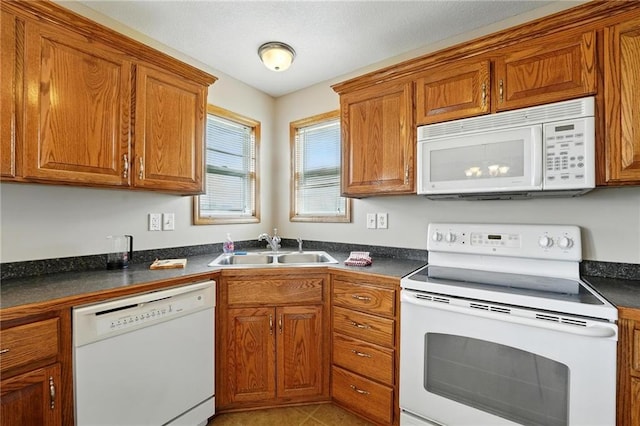 614 SW Tisha Ln, Grain Valley, MO 64029 - kitchen with white appliances, brown cabinets, and dark countertops