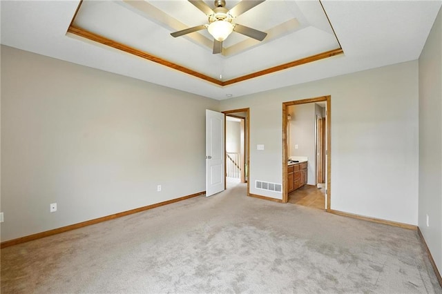 614 SW Tisha Ln, Grain Valley, MO 64029 - unfurnished bedroom featuring a raised ceiling, light carpet, and connected bathroom