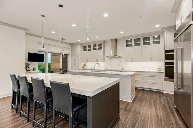 400 W 49th Ter Unit 2106, Kansas City, MO 64112 - kitchen with wall chimney range hood, a large island with sink, dark wood-style floors, high quality fridge, and recessed lighting