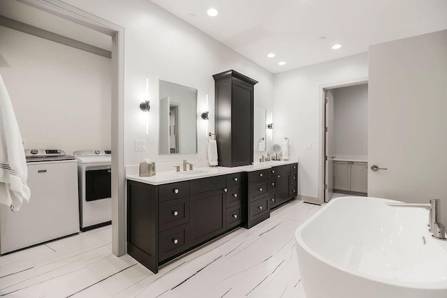 400 W 49th Ter Unit 2106, Kansas City, MO 64112 - full bathroom featuring washing machine and dryer, double vanity, a freestanding tub, recessed lighting, and marble finish floors