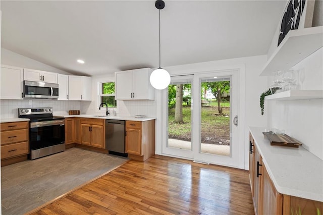 3523 Drumm Ave, Independence, MO 64055 - kitchen featuring stainless steel appliances, open shelves, a sink, backsplash, and light wood finished floors