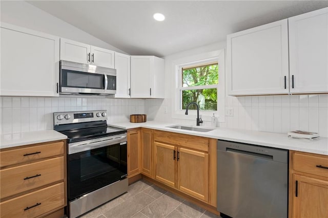 3523 Drumm Ave, Independence, MO 64055 - kitchen with stainless steel appliances, a sink, lofted ceiling, decorative backsplash, and light countertops