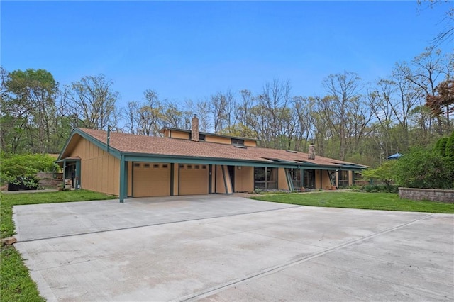 19913 Pepper Tree Rd, Edgerton, KS 66021 - view of front of home with a garage, a front lawn, a chimney, and driveway