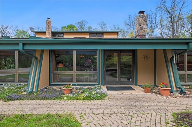 19913 Pepper Tree Rd, Edgerton, KS 66021 - entrance to property with a chimney and stucco siding