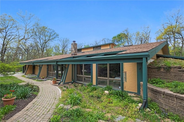 19913 Pepper Tree Rd, Edgerton, KS 66021 - back of house with a chimney, stucco siding, and a shingled roof