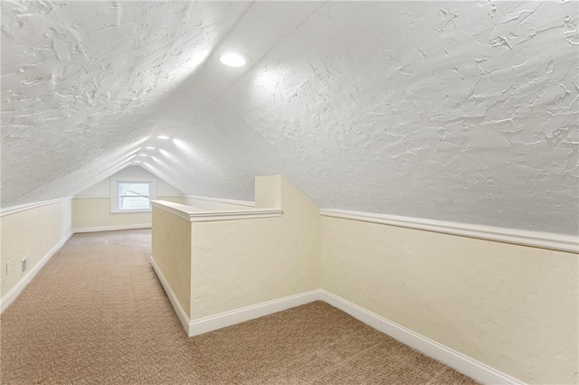 8424 Ward Parkway Plz, Kansas City, MO 64114 - additional living space featuring a textured ceiling, vaulted ceiling, light colored carpet, and a textured wall
