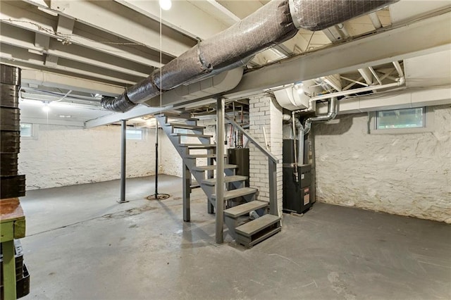 8424 Ward Parkway Plz, Kansas City, MO 64114 - below grade area with stairs, heating unit, and plenty of natural light
