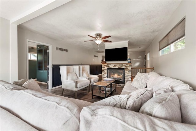 37 Beach Dr, Blue Springs, MO 64015 - living area featuring wood finished floors, a textured ceiling, ceiling fan, and a stone fireplace