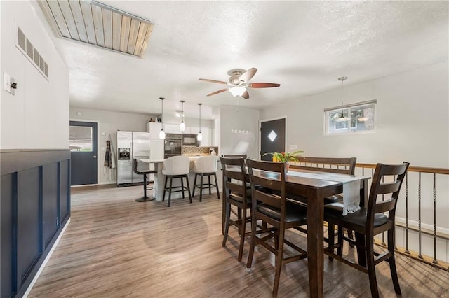 37 Beach Dr, Blue Springs, MO 64015 - dining room with ceiling fan, light wood finished floors, a textured ceiling, and baseboards