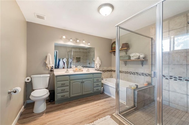 37 Beach Dr, Blue Springs, MO 64015 - bathroom with double vanity, a garden tub, wood finished floors, toilet, and a shower stall