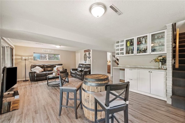 37 Beach Dr, Blue Springs, MO 64015 - dining space with light wood finished floors, a textured ceiling, and stairway