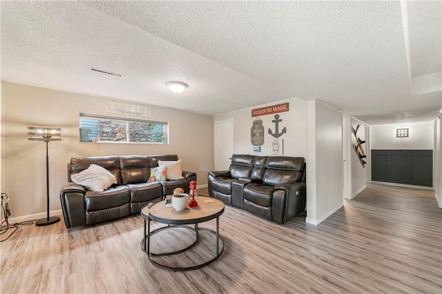 37 Beach Dr, Blue Springs, MO 64015 - living area with a textured ceiling, light wood-style flooring, and baseboards