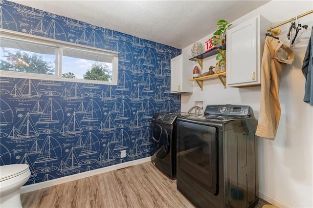 37 Beach Dr, Blue Springs, MO 64015 - laundry room with wallpapered walls, washer and dryer, light wood-type flooring, baseboards, and a textured ceiling